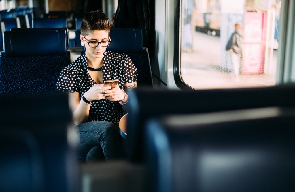 Millenial young woman texting on train