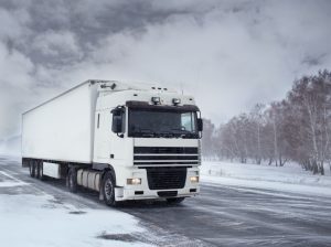 a truck driving through a snowy winter area