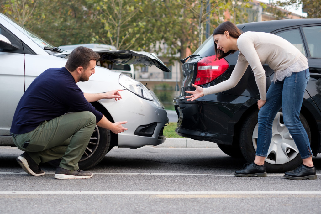 male and female drivers discussing the damage on their cars